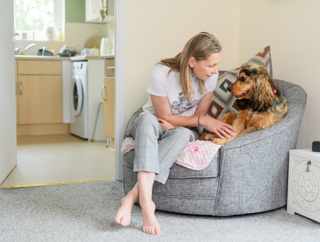 A tenant sitting in a chair with her dog