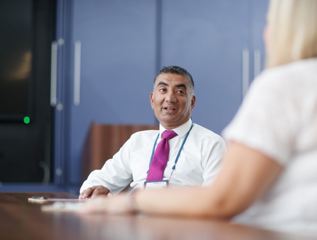 A Midland Heart employee sat at a desk talking to someone