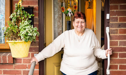 Tenant Standing In Doorway Holding A Support Rail