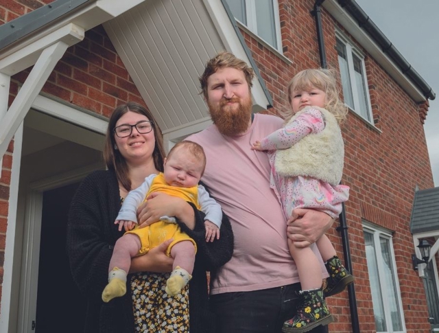 A family standing in front of their home (1)