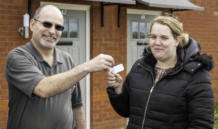 A tenant receiving the key to their new home