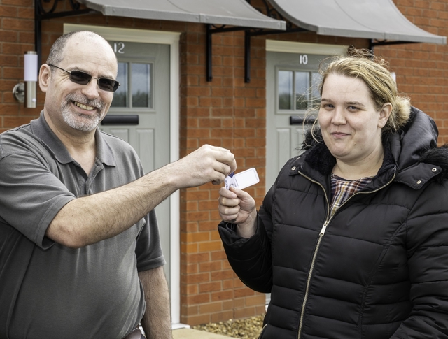 A tenant receiving the key to their new home