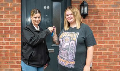 A tenant receiving the key to their new home from a Midland Heart employee