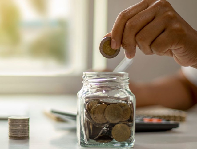 A person saving money in a jar