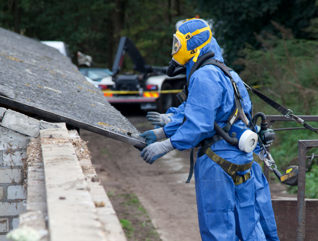 People in protective suits staring at a roof