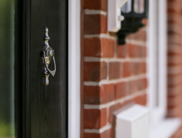 Close up photo of a front door and the knocker