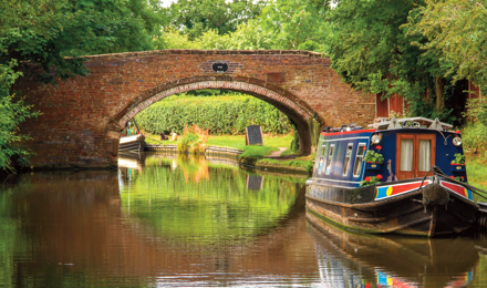 A canal with a bridge and a barge in The Black Country