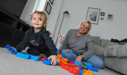 A mother and daughter playing building blocks on the floor of their living room