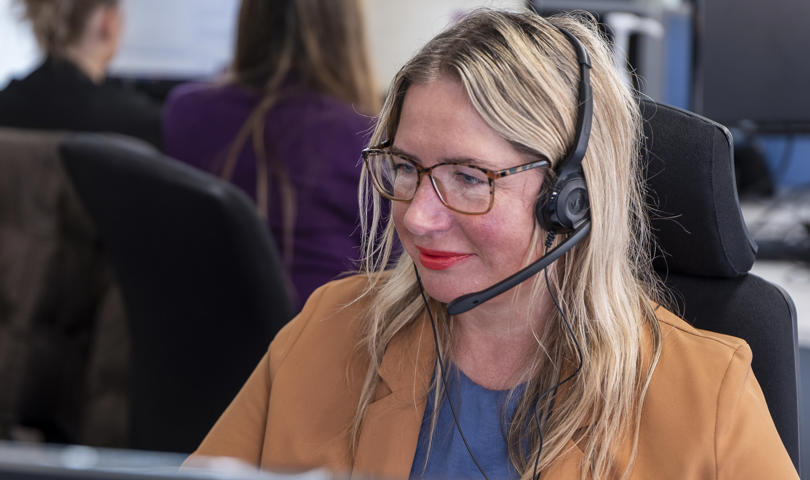 A Midland Heart employee with a headset looking at their computer